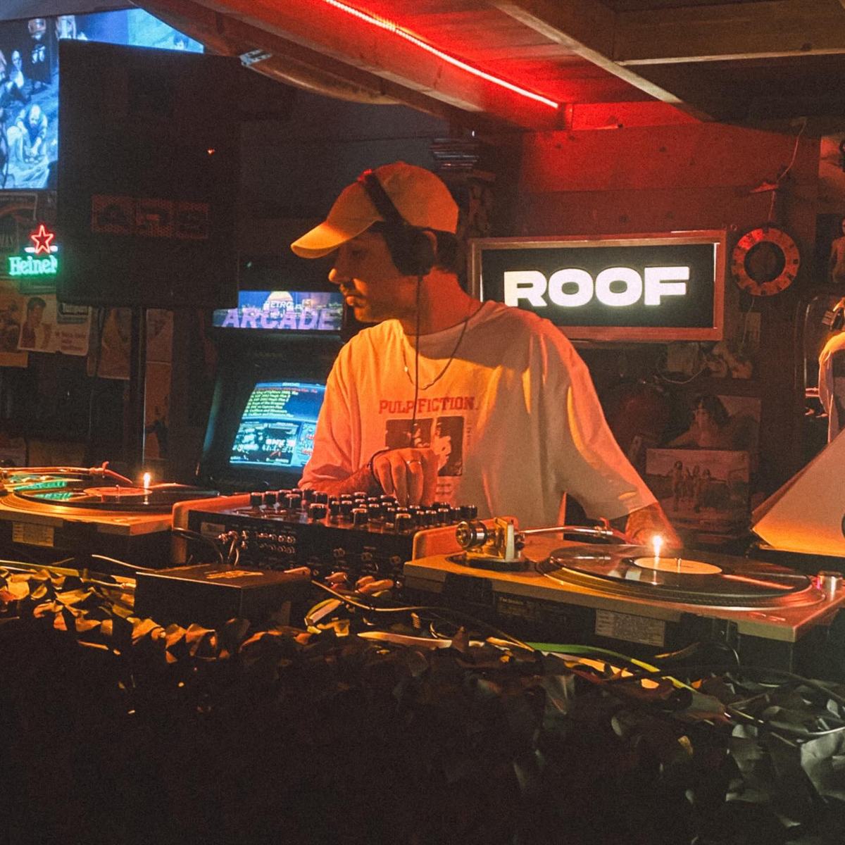 DJ in front of the ROOF sign